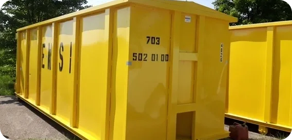 Two yellow containers sitting in a parking lot.